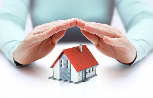 hands covering house - insurance concept - real estate