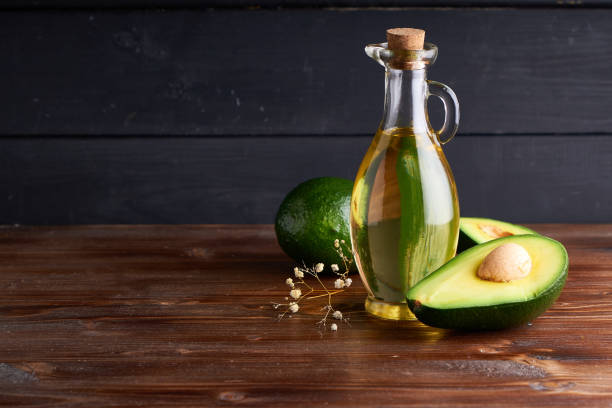 Healthy Avocado oil in glass bottles. Dark wooden background Copy space